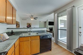 A kitchen with wooden cabinets and a granite countertop.